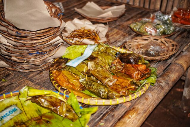 Tarabă dintr-o piață în aer liber, cu roșii, ardei, ierburi aromatice și legume proaspete de sezon